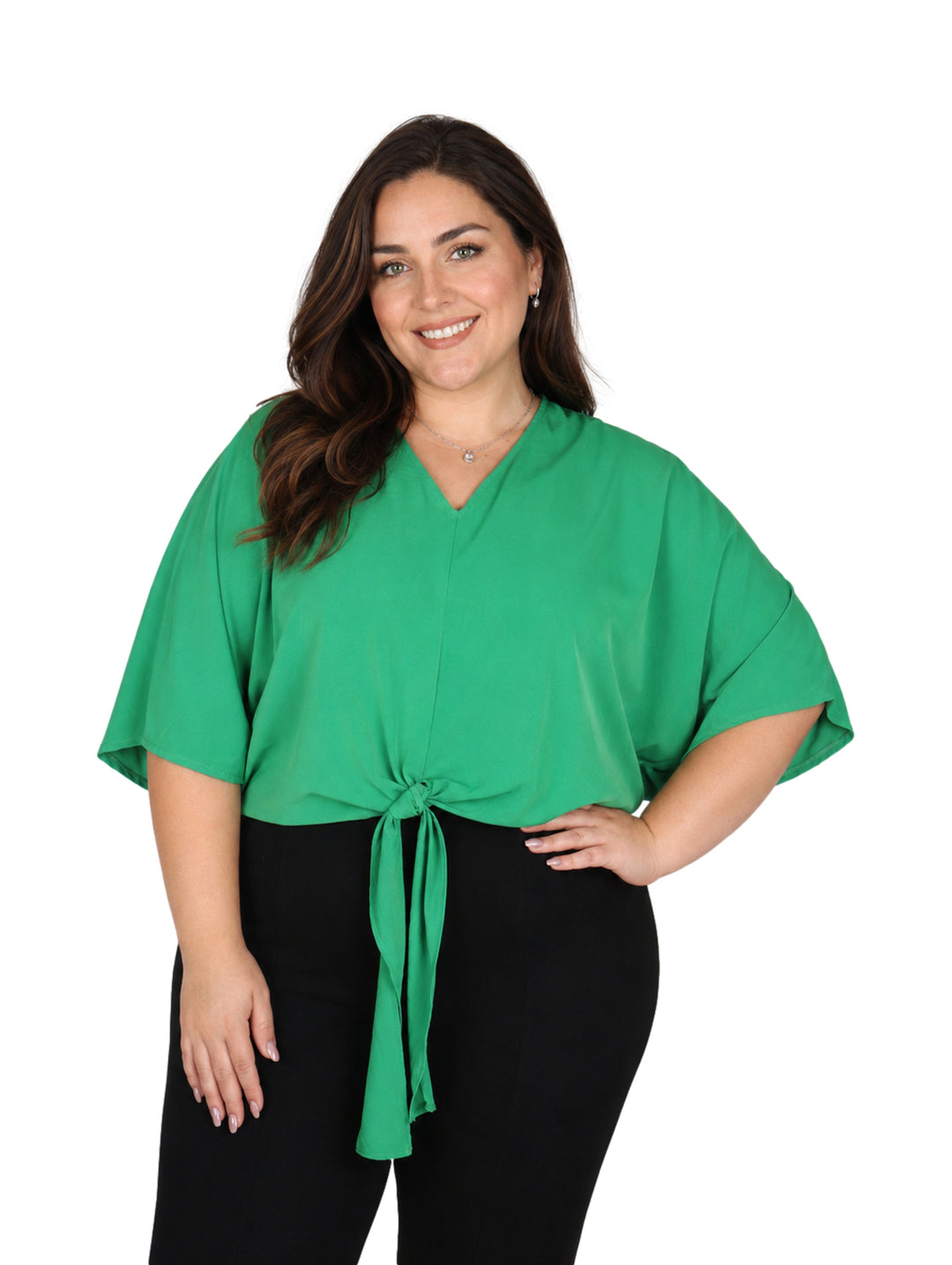 Mujer vistiendo una blusa color verde kelly con amarre frontal y pantalones negros.