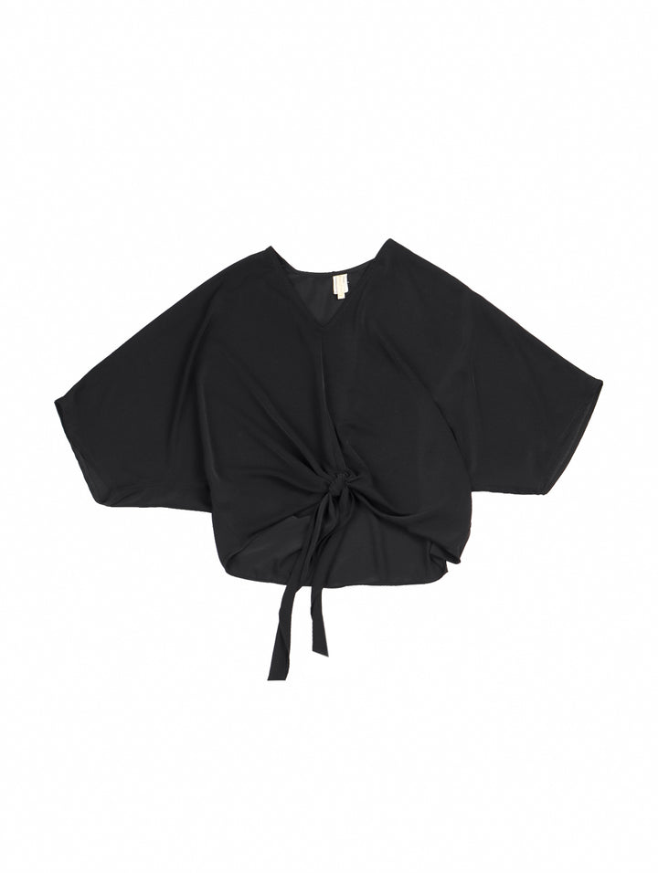 Mujer vistiendo una blusa negra de cuello en V con un nudo decorativo en la cintura.