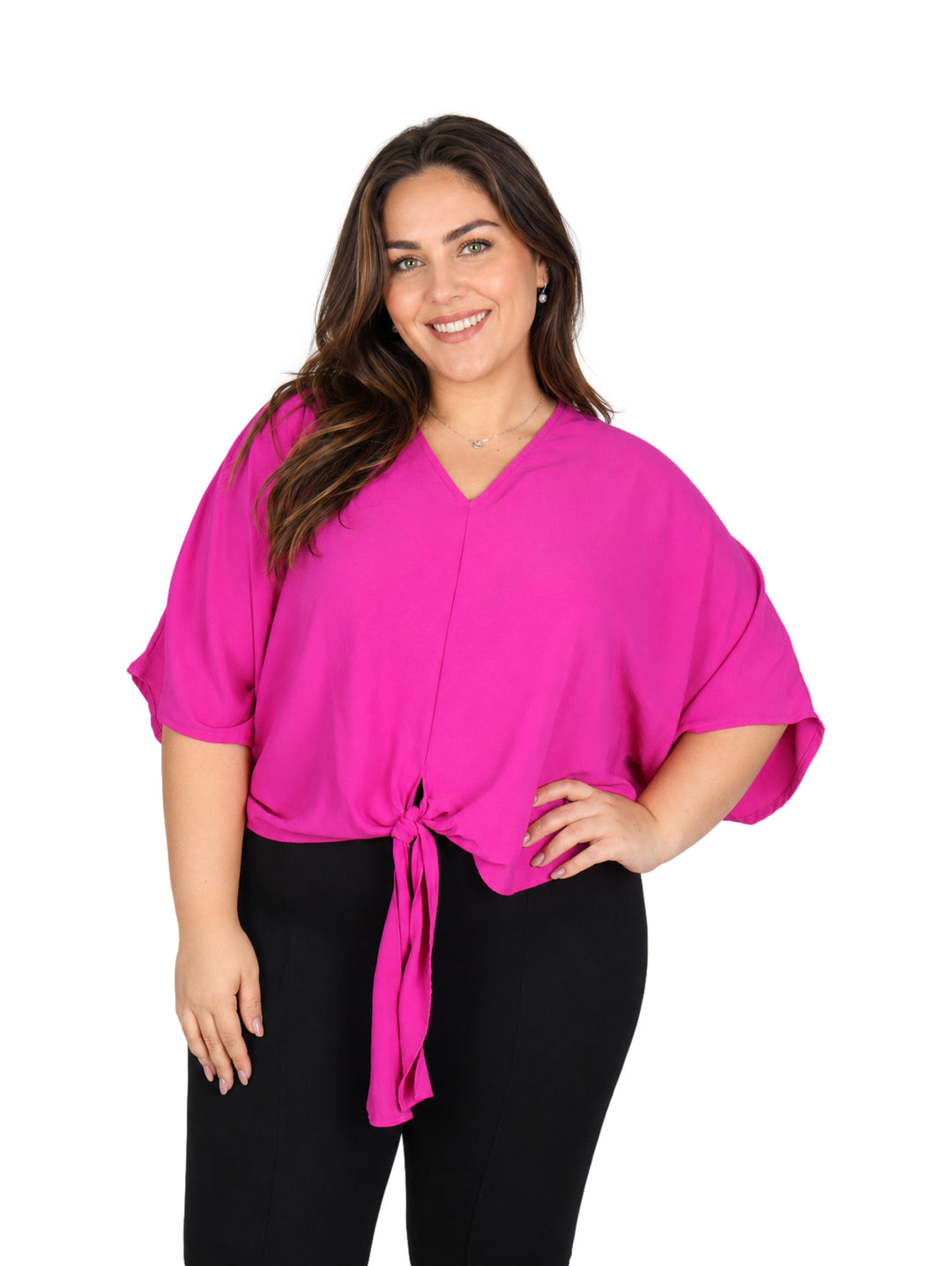 Mujer vistiendo una blusa color rosa intenso con cuello en V y detalle de nudo en la cintura.