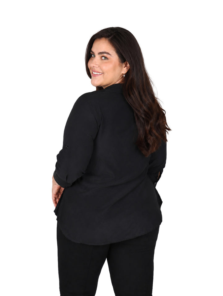Mujer vistiendo un conjunto de ropa color negro compuesto por blusa y pantalón.