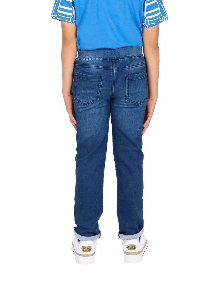 Pantalón recto de mezclilla azul para niño con cintura elástica y cordón ajustable.