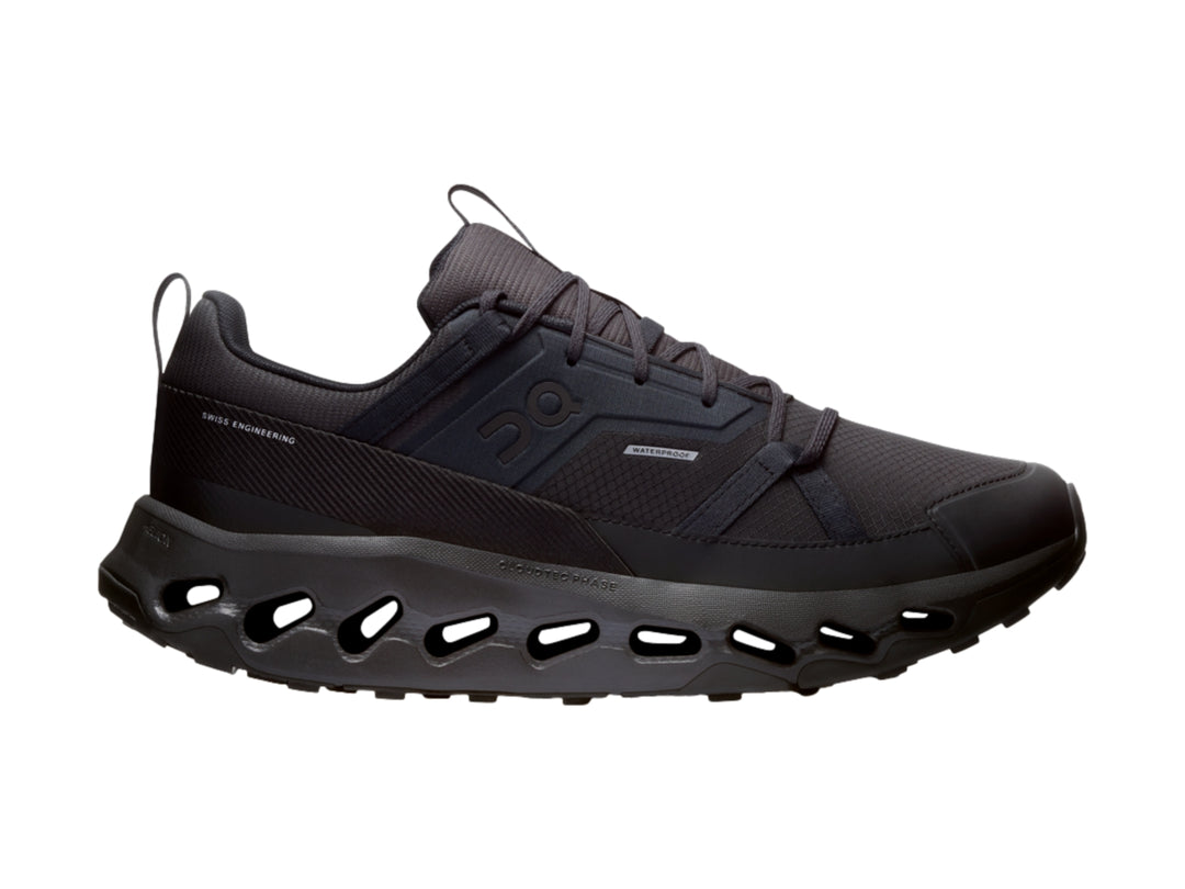 Tenis deportivos On Cloud color negro con suela característica de celdas huecas.