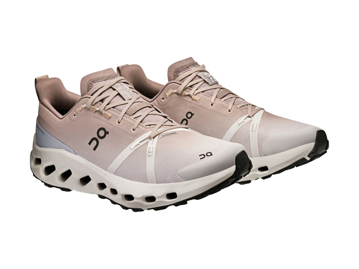 Tenis deportivos On Cloud en color beige y blanco con suela amortiguada para trail.