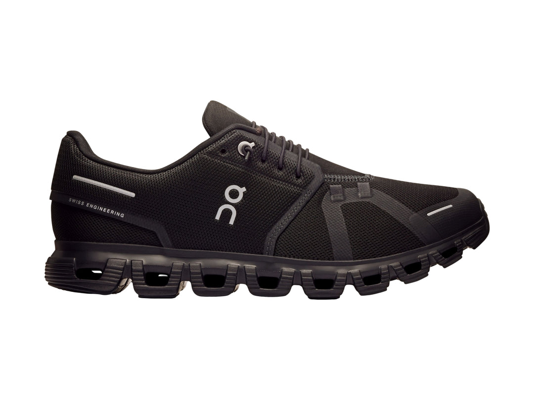 Tenis deportivos On Cloud color negro total con suela característica de nubes y tejido transpirable.
