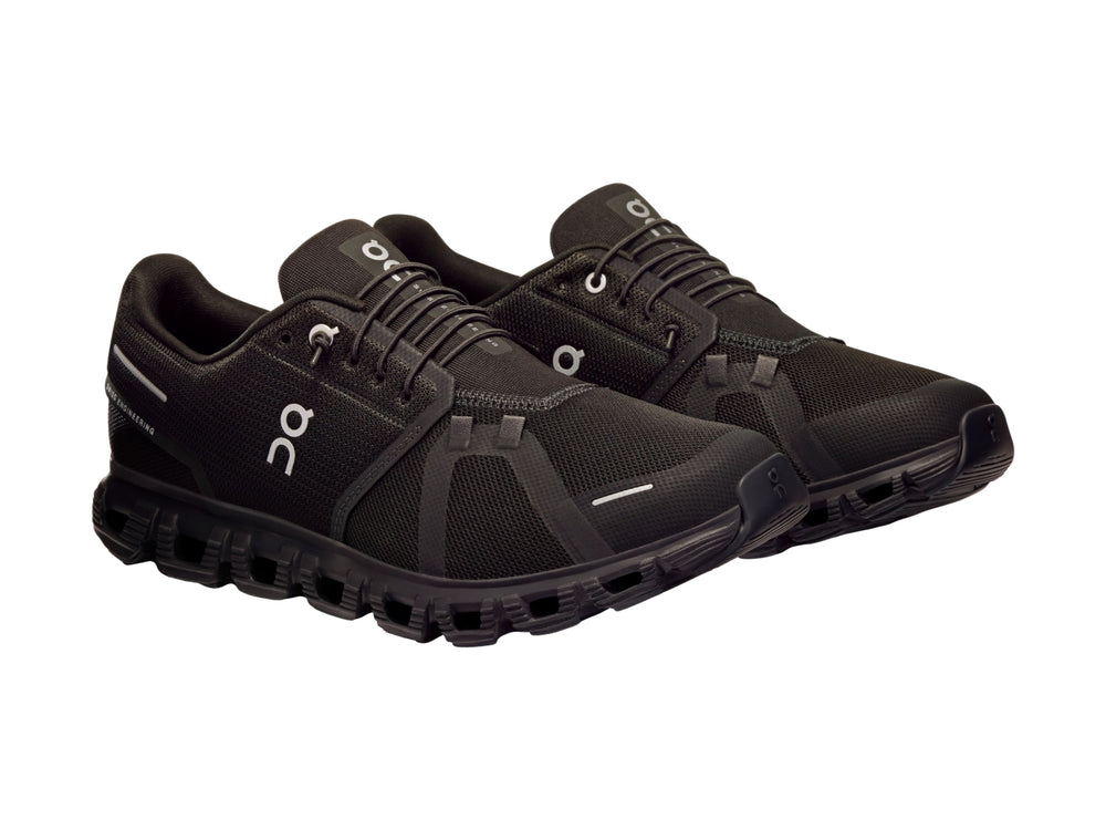 Tenis deportivos On Cloud color negro total con suela característica de nubes y tejido transpirable.