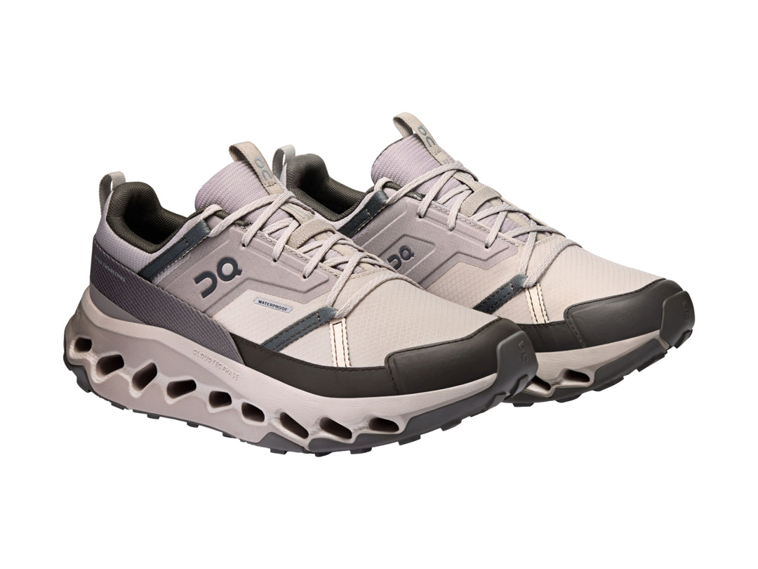 Tenis deportivos On Cloud color Desert Thorn con suela característica perforada y detalles en gris oscuro.