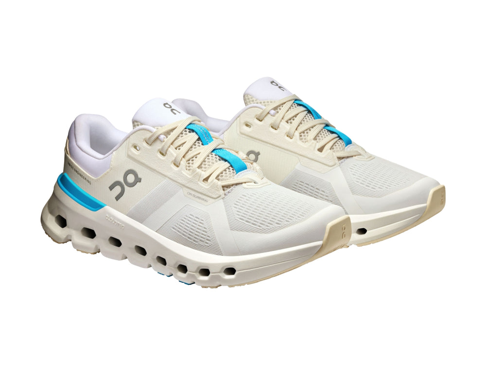 Tenis deportivos On Cloud color blanco con detalles en azul y suela con tecnología de amortiguación característica.