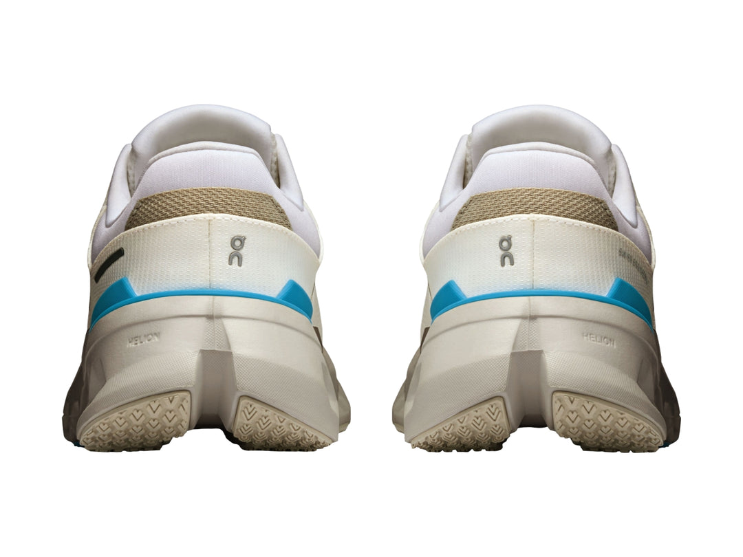 Tenis deportivos On Cloud color blanco con detalles en azul y suela con tecnología de amortiguación característica.