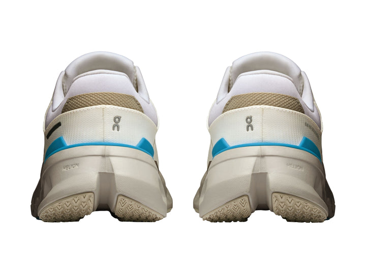 Tenis deportivos On Cloud color blanco con detalles en azul y suela con tecnología de amortiguación característica.