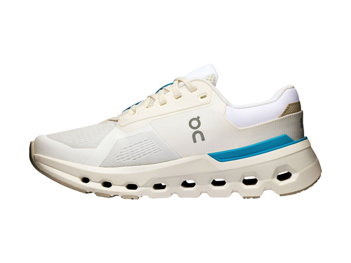 Tenis deportivos On Cloud color blanco con detalles en azul y suela con tecnología de amortiguación característica.