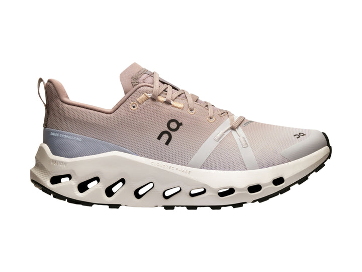 Tenis deportivos On Cloud color beige y blanco con suela gruesa para trail running.