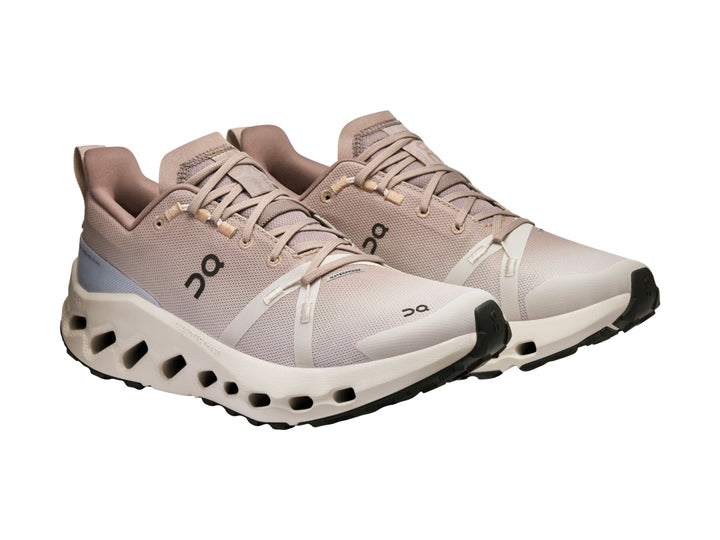 Tenis deportivos On Cloud color beige y blanco con suela gruesa para trail running.
