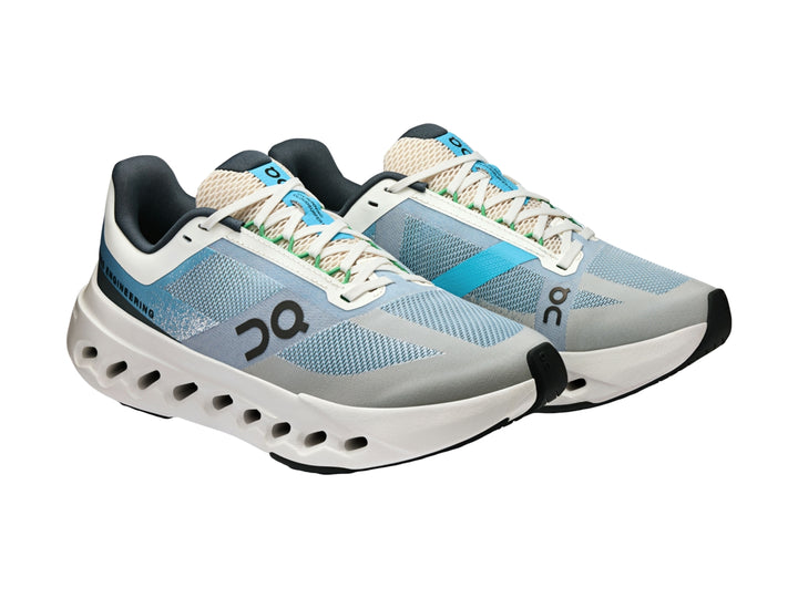 Tenis deportivos ON Cloudsurfer Next color blanco y azul con suela blanca característica.