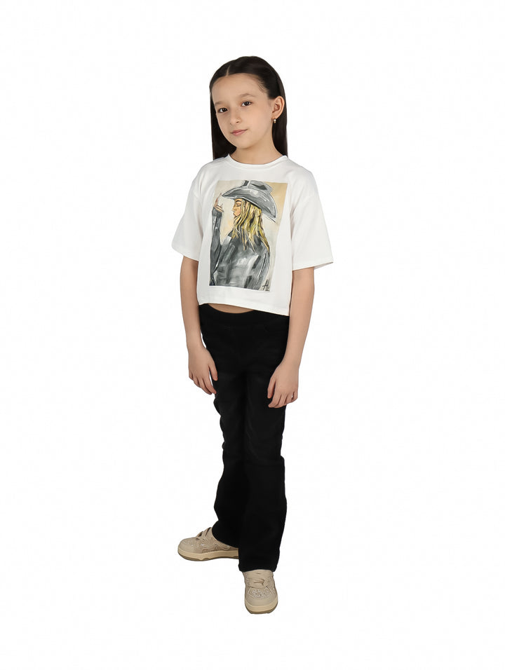 Niña vistiendo pantalón largo color negro de corte acampanado y tenis beige.