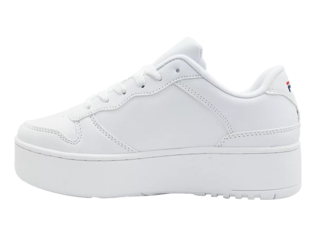 Tenis Fila blancos de plataforma con logotipo en azul y rojo sobre fondo blanco.