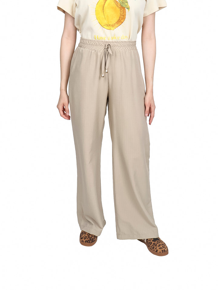 Pantalón beige de pierna ancha con cintura elástica y cordón ajustable.