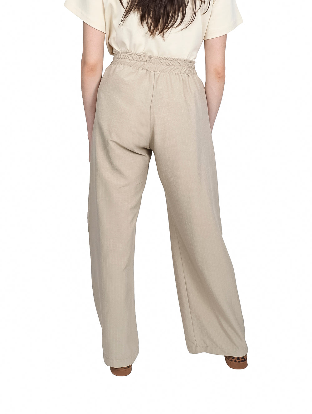 Pantalón beige de pierna ancha con cintura elástica y cordón ajustable.