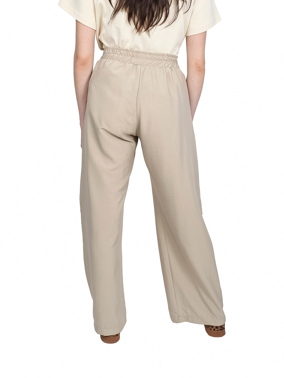 Pantalón beige de pierna ancha con cintura elástica y cordón ajustable.