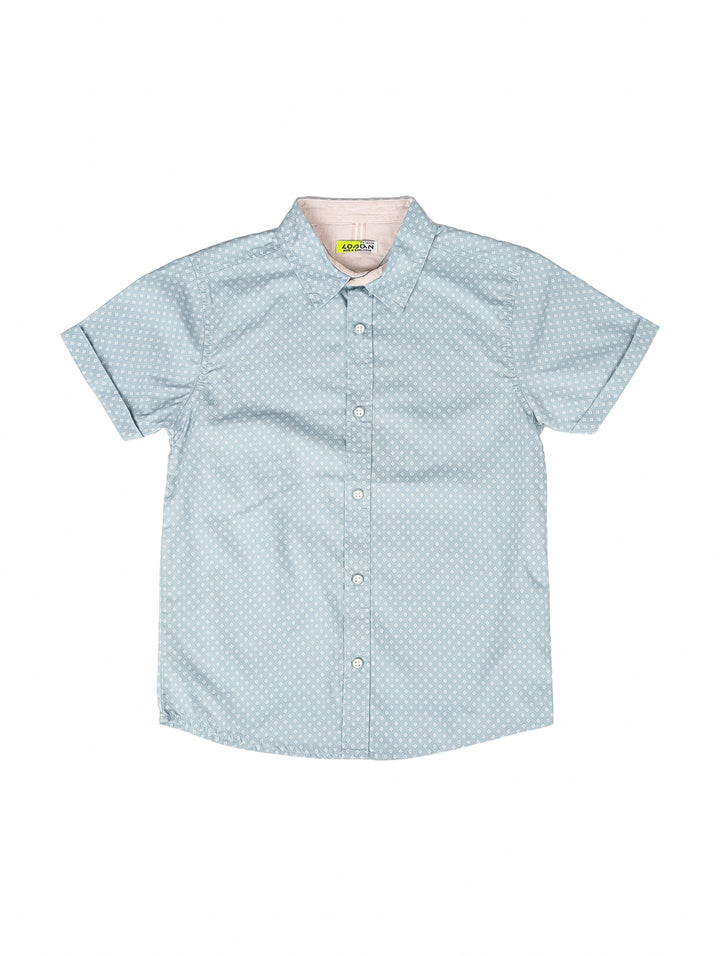 Camisa azul claro para niño con estampado de lunares blancos y manga corta.