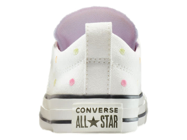 Tenis Converse blancos de lona con lunares de colores y suela blanca.
