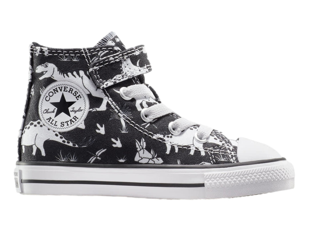 Tenis Converse Chuck Taylor All Star negros con estampado de dinosaurios blancos, punta blanca y cierre de velcro.