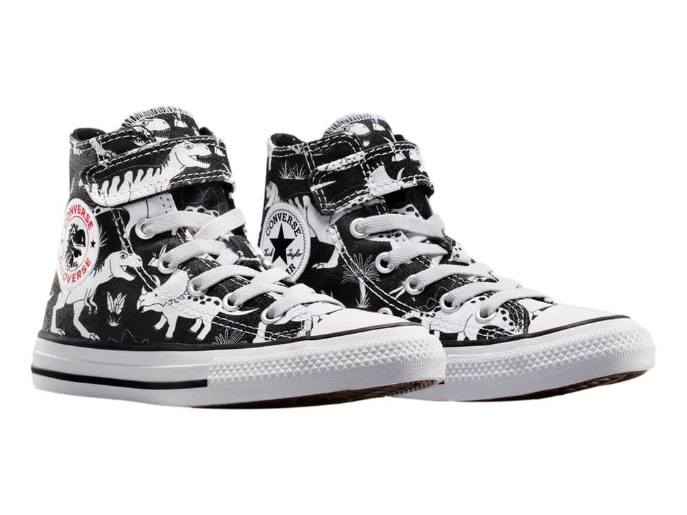 Tenis Converse Chuck Taylor All Star negros con estampado de dinosaurios blancos, punta blanca y cierre de velcro.