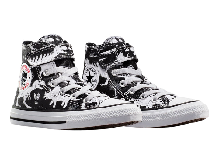 Tenis Converse Chuck Taylor All Star negros con estampado de dinosaurios blancos, punta blanca y cierre de velcro.