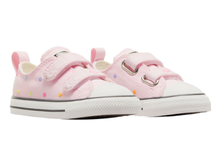 Tenis Converse rosa con lunares multicolores, cierre de velcro y suela blanca.