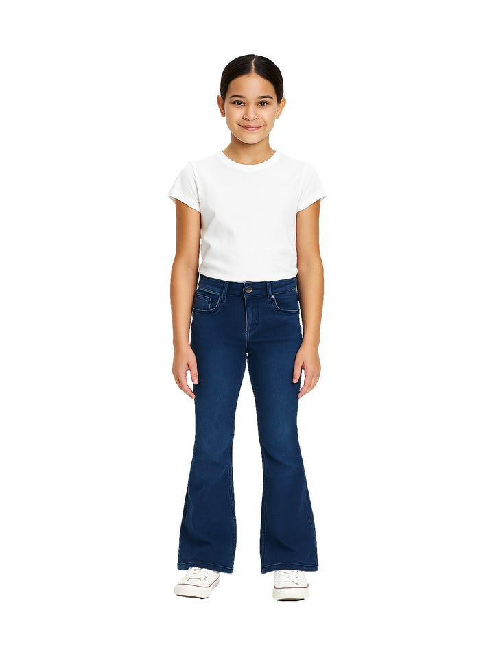 Niña vistiendo pantalón de mezclilla azul oscuro de corte acampanado y playera blanca.