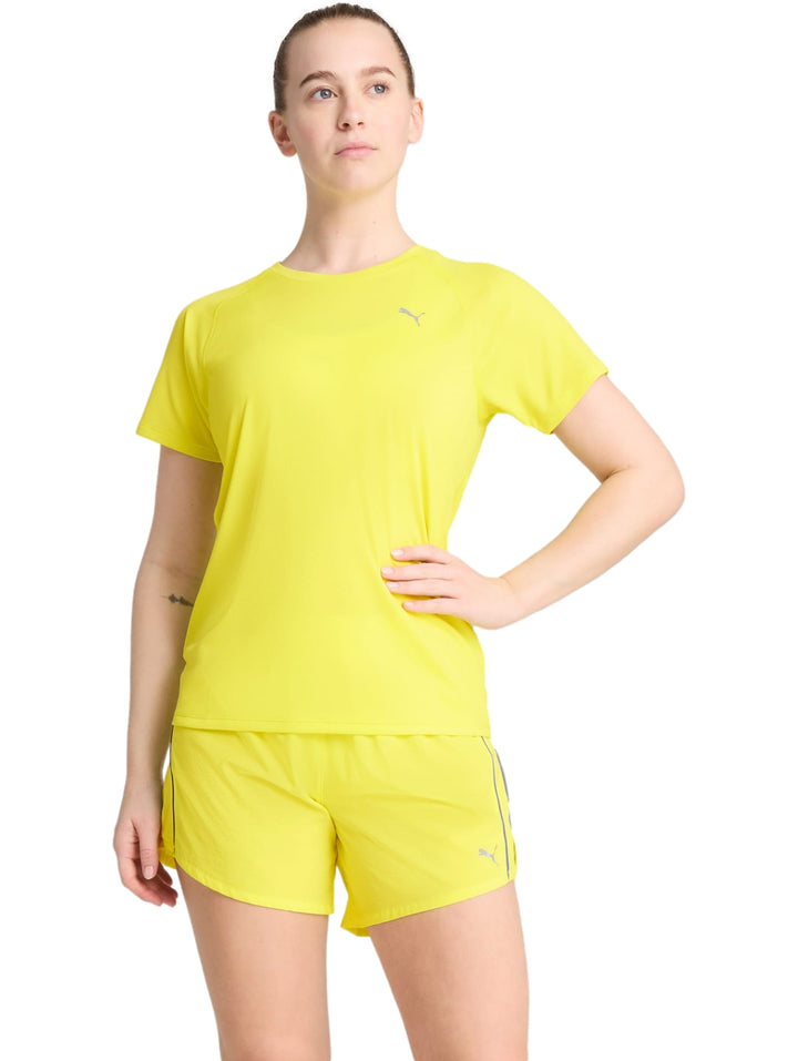 Mujer vistiendo conjunto deportivo PUMA color amarillo limón compuesto por camiseta de manga corta y shorts.