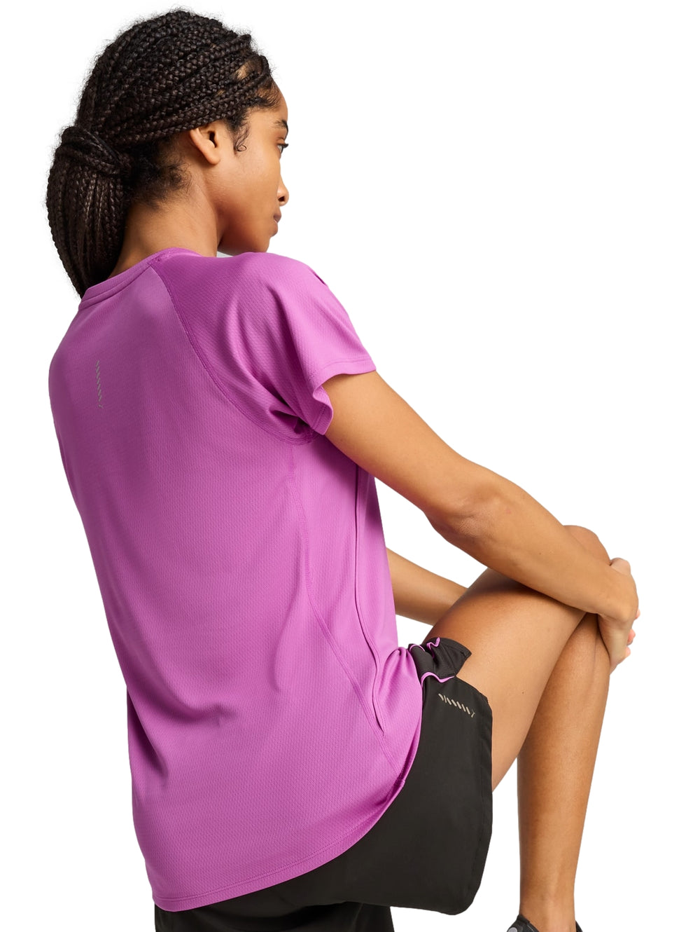 Mujer vistiendo playera deportiva PUMA color Wild Berry de manga corta y cuello redondo.