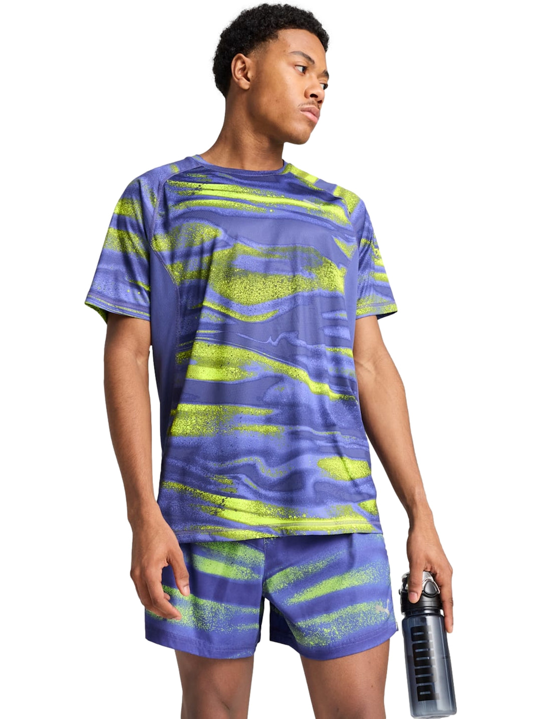 Hombre vistiendo conjunto deportivo PUMA azul con estampado abstracto verde lima.