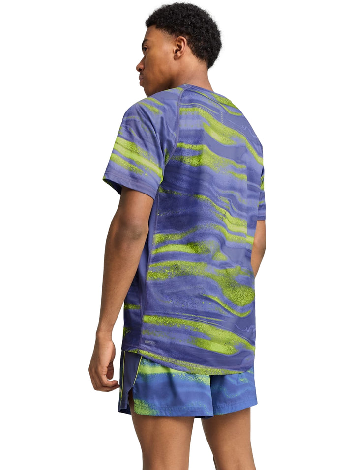 Hombre vistiendo conjunto deportivo PUMA azul con estampado abstracto verde lima.