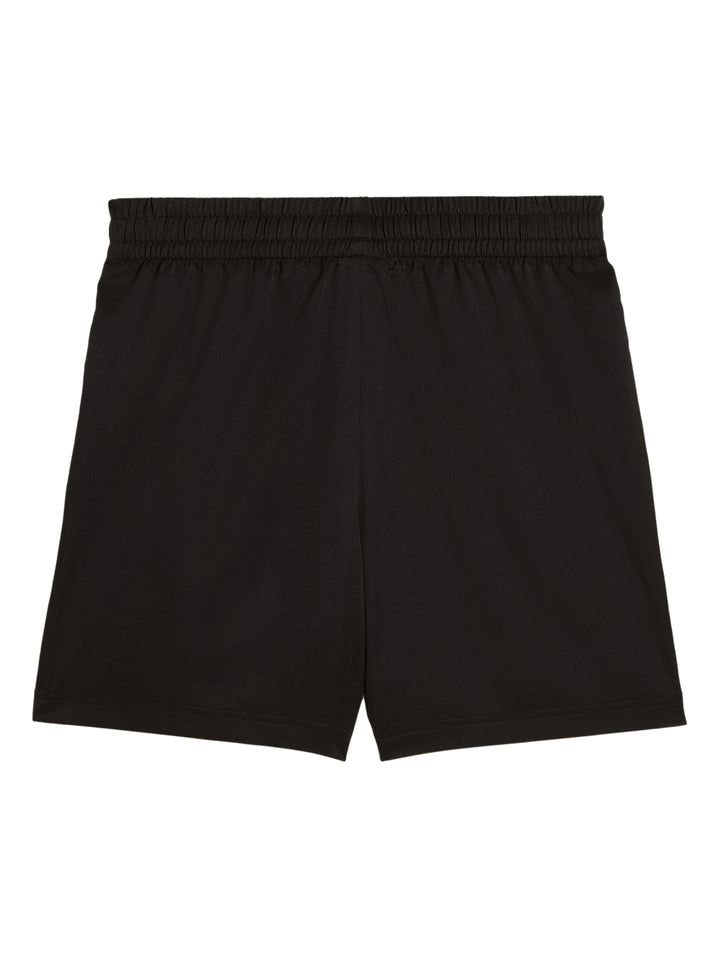 Hombre vistiendo shorts deportivos PUMA de color negro, calcetines blancos y tenis blancos.