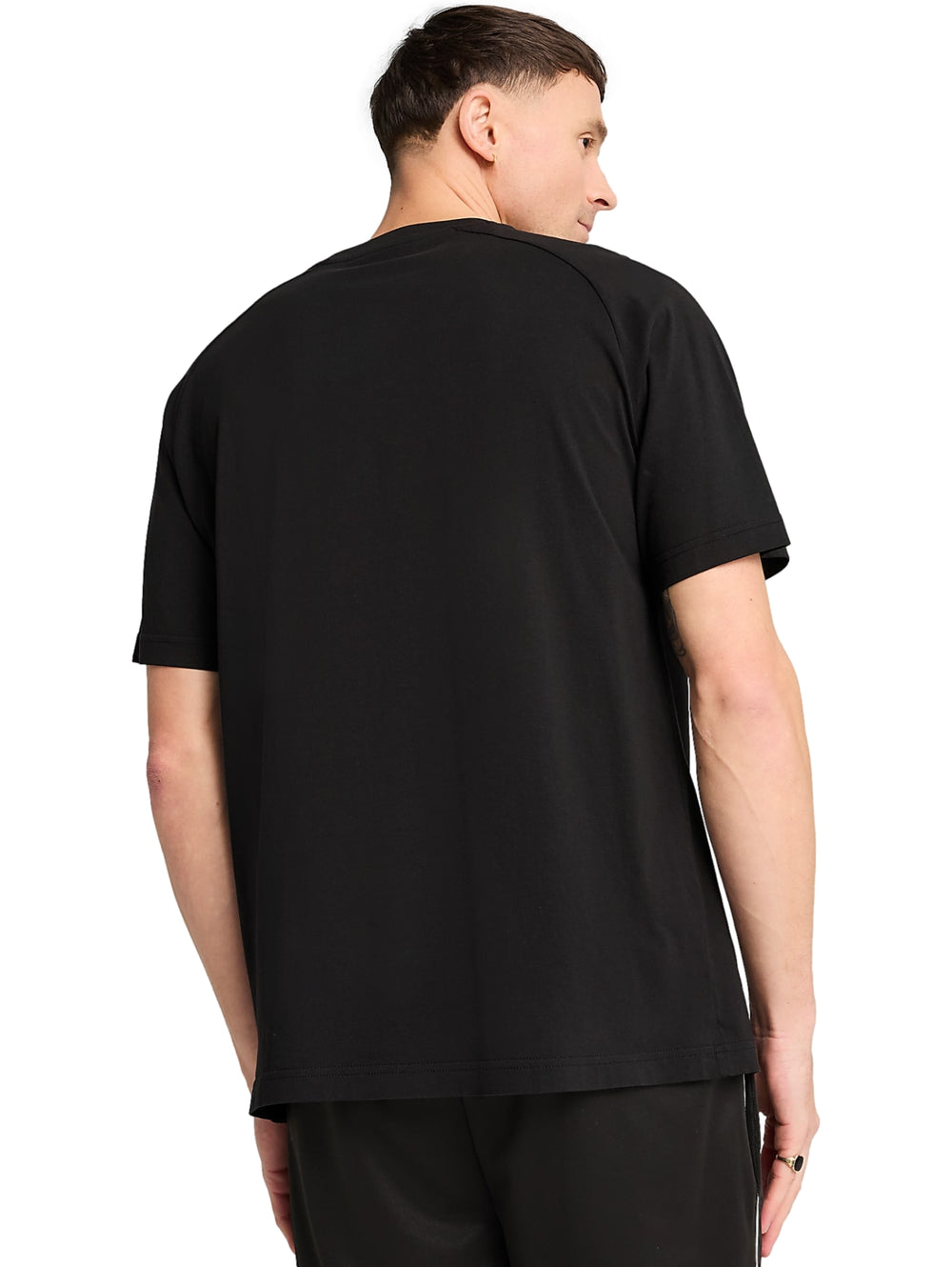 Hombre vistiendo camiseta deportiva PUMA de color negro con detalles blancos en los hombros.