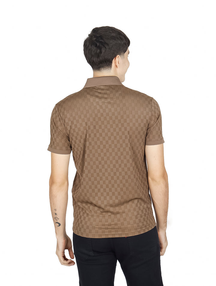 Hombre vistiendo una playera polo color marrón con patrón cuadriculado y manga corta.