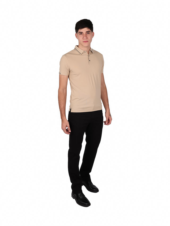 Hombre vistiendo polo beige de manga corta con detalles decorativos en el cuello y puños.