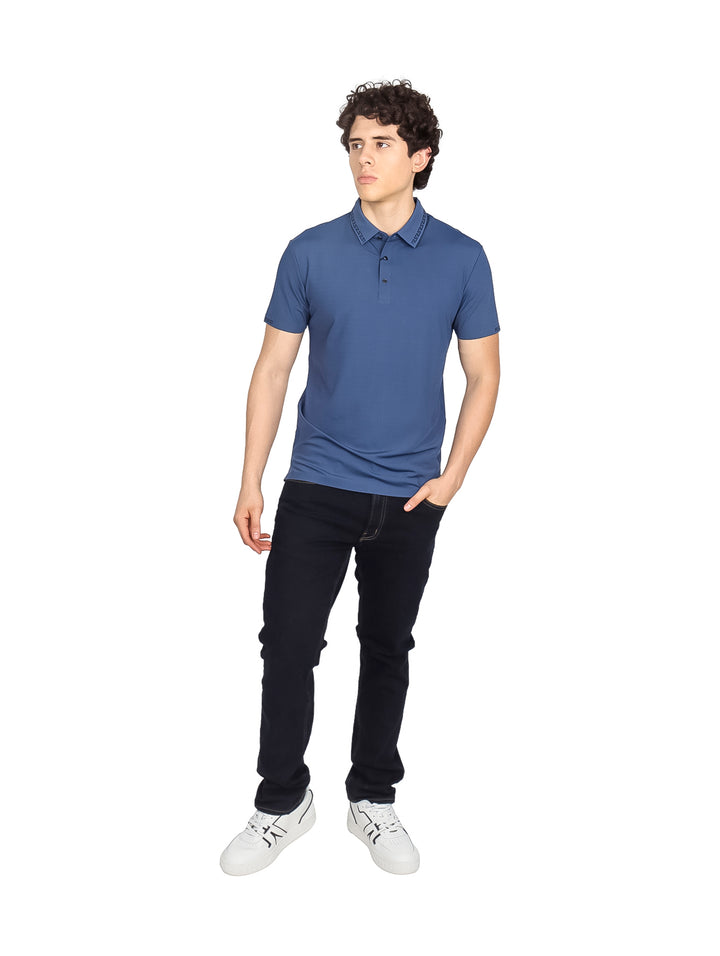 Hombre vistiendo una playera polo de color azul marino de manga corta.