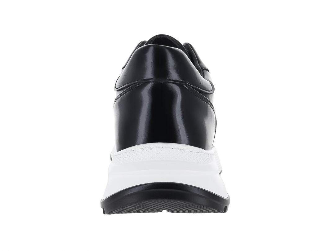 Tenis casuales de color negro con suela gruesa blanca y cordones negros.
