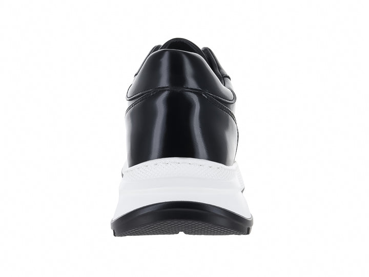 Tenis casuales de color negro con suela gruesa blanca y cordones negros.