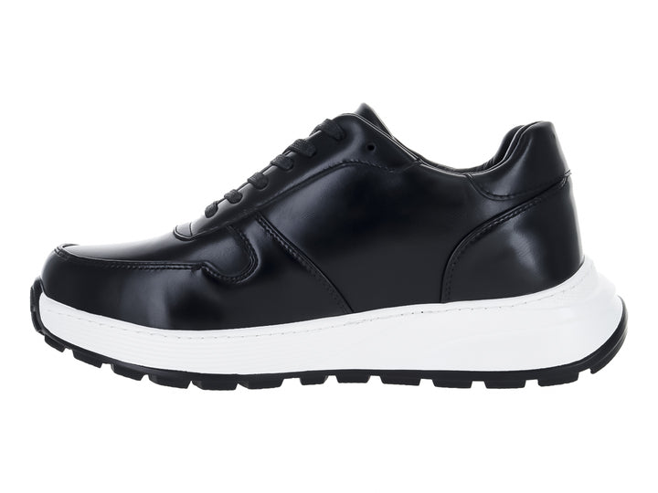 Tenis casuales de color negro con suela gruesa blanca y cordones negros.