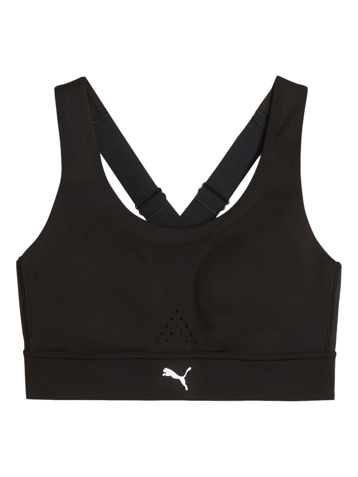 Mujer modelando un bra deportivo PUMA color negro y shorts color amarillo neón.