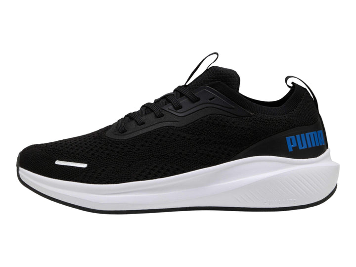 Tenis deportivos PUMA color negro con suela blanca y logo azul en el costado.