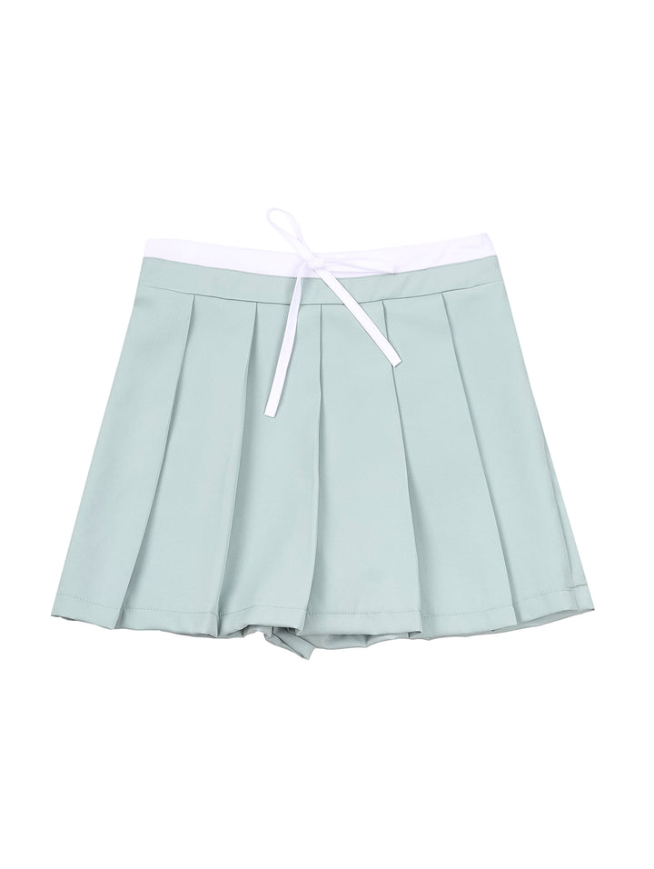 Mujer vistiendo una falda corta de color menta con tablones y cintura ajustable.