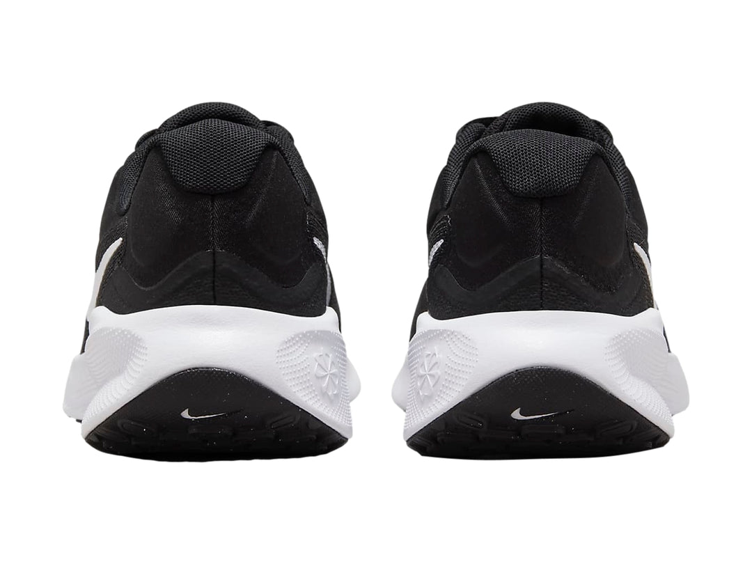 Tenis Nike Revolution 7 color negro con suela y logotipo blanco, vista lateral.