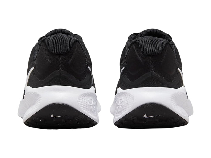 Tenis Nike Revolution 7 color negro con suela y logotipo blanco, vista lateral.