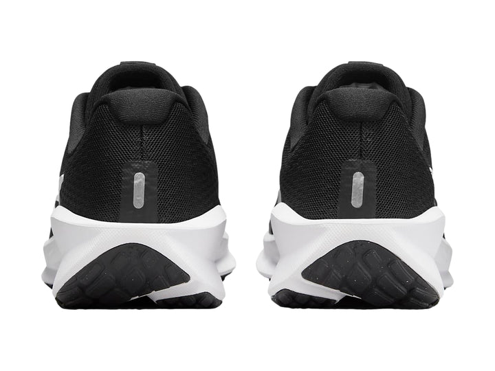 Tenis deportivos Nike Downshifter 13 color negro con suela blanca y logotipo Nike en blanco.