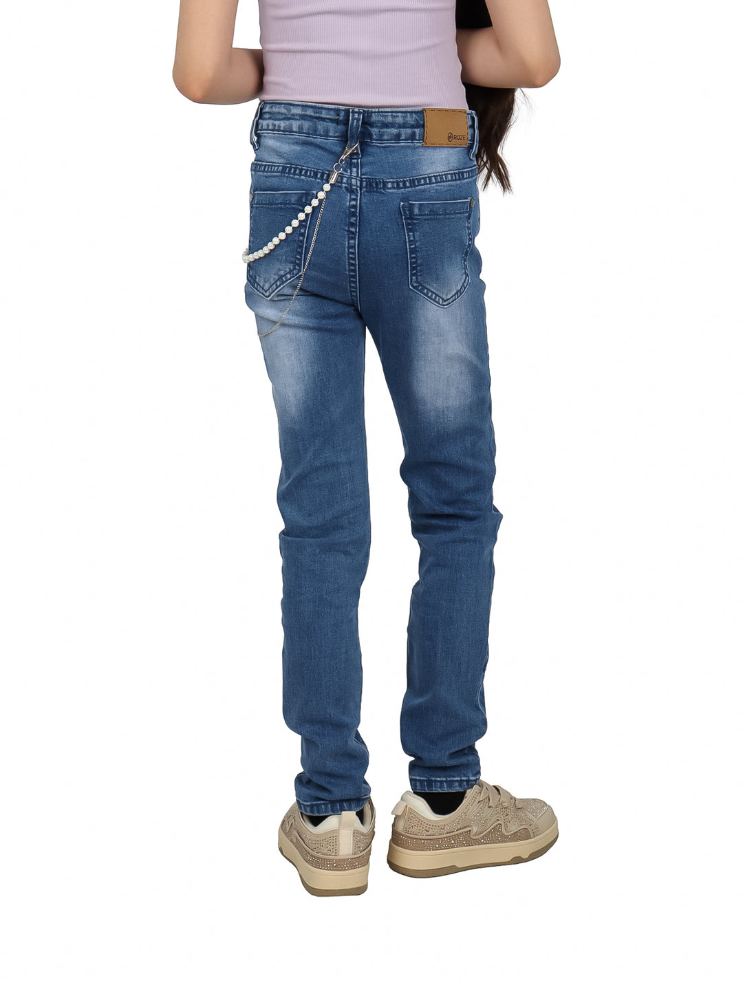 Pantalón de mezclilla azul para niña con detalles de flores blancas y una cadena decorativa lateral.