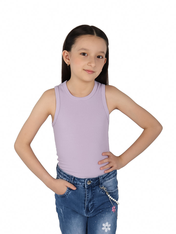 Niña vistiendo blusa lila sin mangas y pantalones de mezclilla azules.