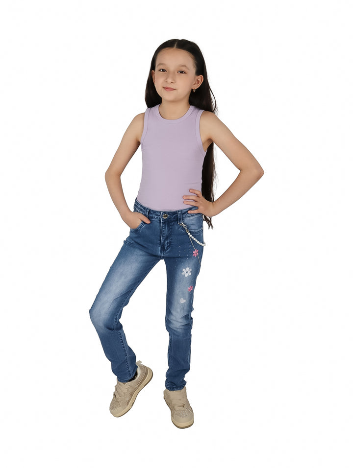 Niña vistiendo blusa lila sin mangas y pantalones de mezclilla azules.